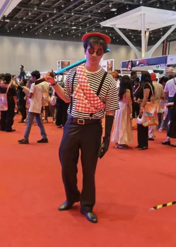 Full-body striped costume portrait with a red beret on the convention floor