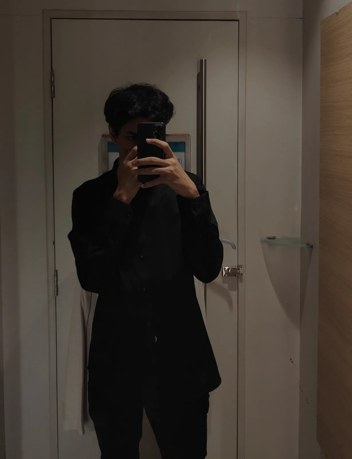 Dark mirror portrait in an all-black outfit