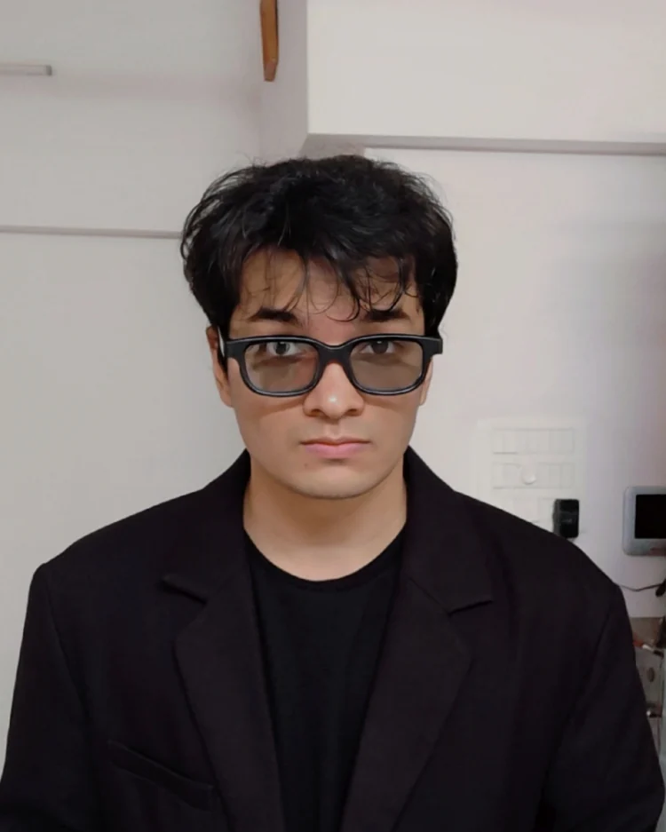 Portrait of Mohamed Ayyan Kazia in a black blazer and glasses
